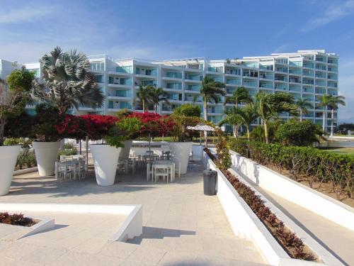 a resort with tables and chairs and a building at ARIA OCEAN ACQUA NUEVO VALLARTA in Nuevo Vallarta