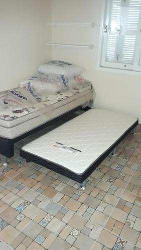 two beds sitting on a tiled floor in a room at Casa Praia de Arroio do Sal - Balneário São Paulo in Arroio do Sal