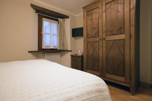 a bedroom with a large wooden cabinet and a bed at Aymon de Challant in Aosta