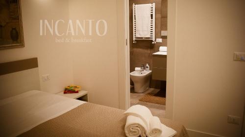 a bedroom with a bed and a bathroom with a toilet at Incanto b&b in Lesina