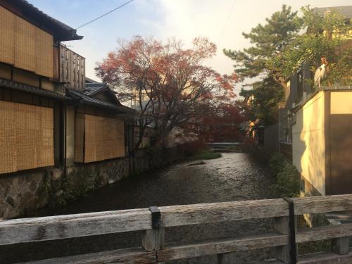 a river between two buildings and a fence at Kyoto Gion U-BELL Hotel in Kyoto