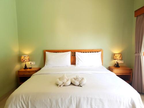 two stuffed animals are sitting on a bed at Naturela in Uluwatu