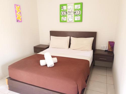 a bedroom with a bed with a cross on it at Naturela in Uluwatu