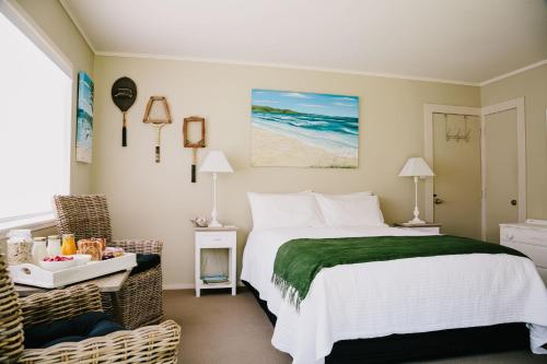 a bedroom with a bed and a table with a chair at Studio on Petley in Tairua