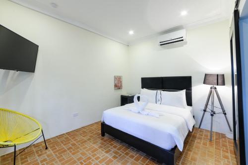 a bedroom with a white bed and a yellow chair at Mario Dive Resort in Panglao