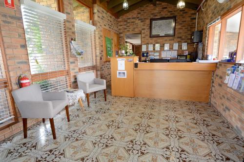 a restaurant with chairs and a counter in a room at Sandhurst Motor Inn Bendigo in Bendigo