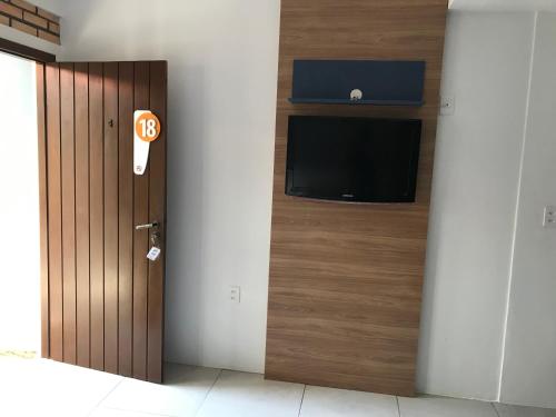 a room with a door with a flat screen tv at Beach House Floripa - Sunset in Florianópolis