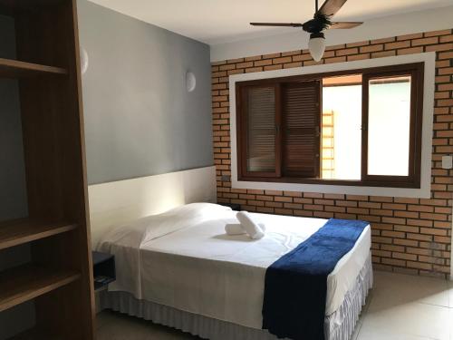 a bedroom with a white bed and a window at Beach House Floripa - Sunset in Florianópolis