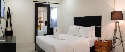 a bedroom with a bed with a mirror and a lamp at Mario Dive Resort in Panglao