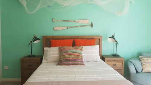 a bedroom with a large bed with two lamps on it at Beachfront Boogaloo in Huskisson