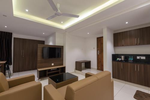 a living room with a couch and a flat screen tv at Hotel Karuna Residency in Mangalore