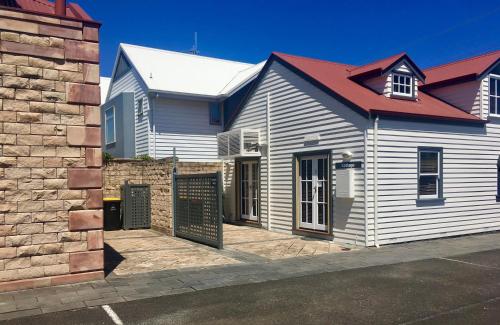 a white house with a red roof at 54 on Bank in Port Fairy