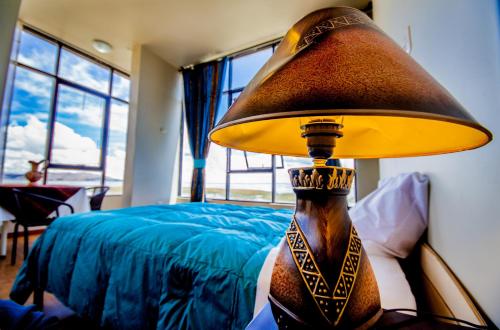 a lamp sitting on a table next to a bed at Yacht Lago Titicaca in Ichu