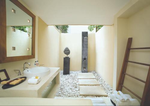 a bathroom with a sink and a mirror at Qunci Villas Resort in Senggigi 