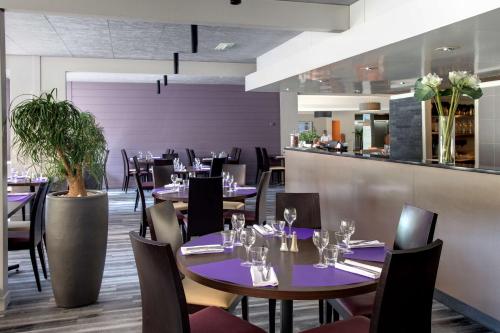 um restaurante com mesas e cadeiras e um bar em Best Western Alexander Park Chambéry em Chambéry