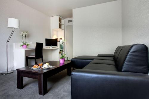 a living room filled with furniture and a coffee table at Best Western Alexander Park Chambéry in Chambéry
