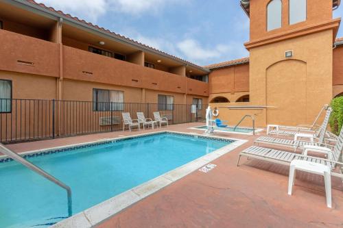 a swimming pool with chairs and a hotel at Quality Inn & Suites Oceanside Near Camp Pendleton in Oceanside