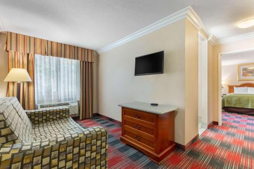 a hotel room with a bedroom with a bed and a couch at Quality Inn & Suites Oceanside Near Camp Pendleton in Oceanside