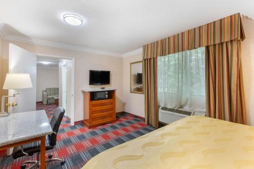 a hotel room with a bed and a desk and a television at Quality Inn & Suites Oceanside Near Camp Pendleton in Oceanside