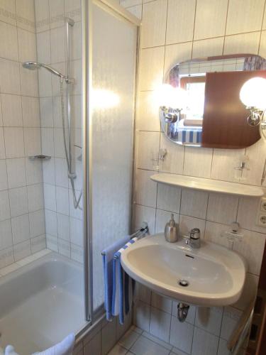 a bathroom with a sink and a shower and a tub at Weingut Hirschen Enkircherweg in Burg (an der Mosel)