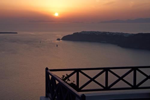 a sunset over a body of water with the sun setting at Ilioperato Hotel in Imerovigli