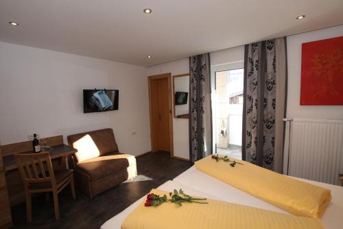 a hotel room with two beds and a living room at Gästehaus Alpina in Sankt Anton am Arlberg