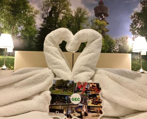 a bed with a white blanket and a toy heart at Gec in Zaprešić