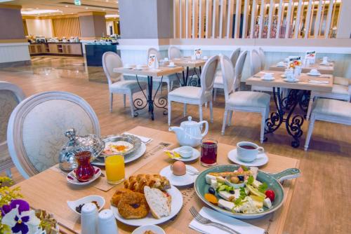 ein Tisch mit Tellern voller Essen darauf in der Unterkunft The Green Park Ankara in Ankara