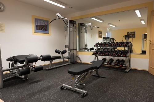 a gym with dumbbells and weights in a room at Glasl's Landhotel in Zorneding