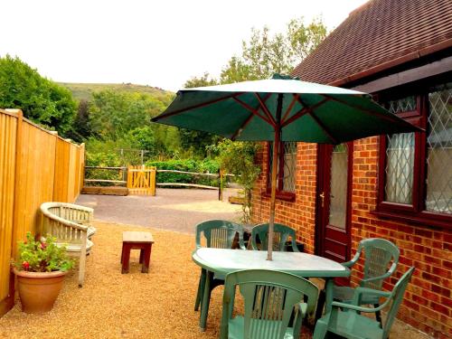 a table and chairs with an umbrella on a patio at Tovey Lodge in Hassocks