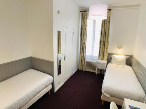 a room with two beds and a window at Cit'Hotel Le Volney in Saumur