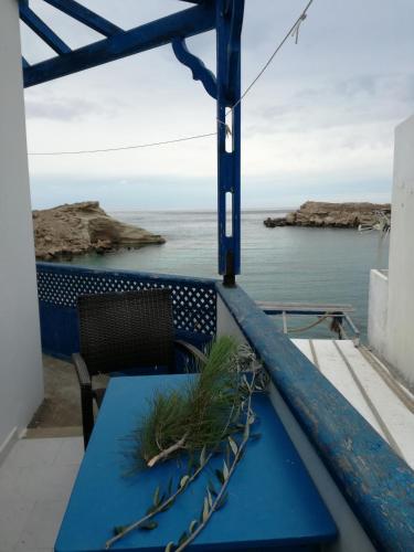 a blue table and chair on a balcony overlooking the ocean at Zorbas Studios in Lefkos Karpathou