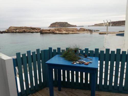 a blue table on a fence with a view of the water at Zorbas Studios in Lefkos Karpathou