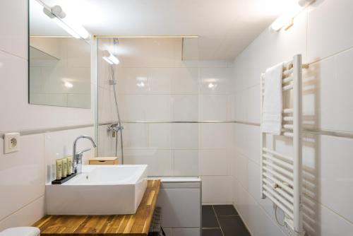 a white bathroom with a sink and a toilet at Honorê - Suites Amboise in Lyon