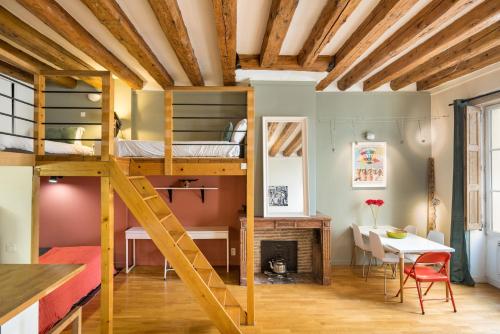 a room with a bunk bed and a dining room at Honorê - Suites Amboise in Lyon