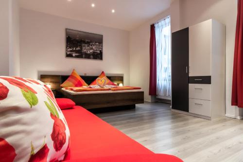 a bedroom with a bed and a red couch at Hotel Martz in Pirmasens