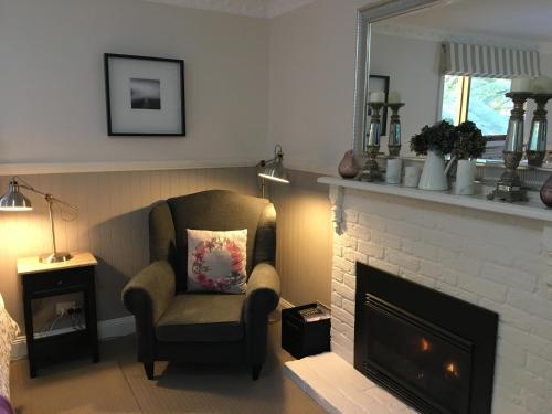 a living room with a chair and a fireplace at Clarendon Cottages in Sassafras