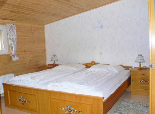 Ferienwohnungen Waldblick في فالدمونشن: سرير كبير في غرفة بها مواقف ليلتين