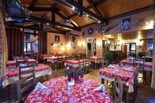 モルジヌにあるHotel Le Solyの赤いテーブルクロスのテーブルと椅子が備わるレストラン