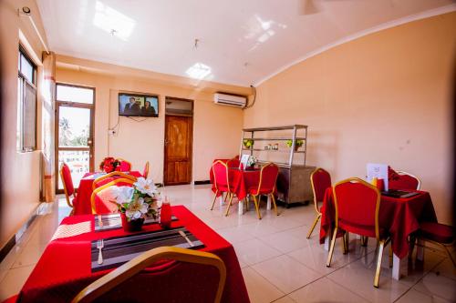 a dining room with red tables and chairs in a room at B10 Airport Lodge in Dar es Salaam
