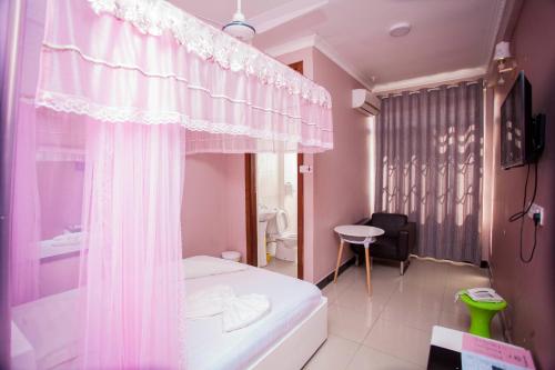 Habitación pequeña con cama y ventana en B10 Airport Lodge en Dar es Salaam