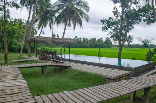 a resort with a pool and a table and chairs at Rice Rice Villas in Tissamaharama