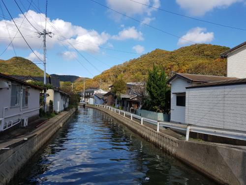 a canal in a town with houses and buildings at Midori Guesthouse&Hostel in Tsushima