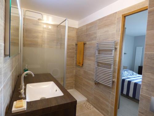 uma casa de banho com um lavatório e um chuveiro em F2 contemporain refait à neuf avec terrasse à 5 minutes de la plage em La Seyne-sur-Mer