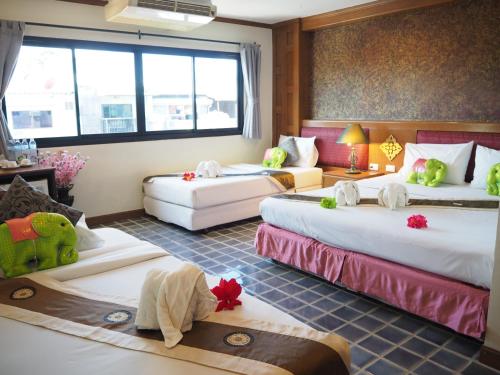 a hotel room with three beds with stuffed animals on them at Your Place Inn in Karon Beach