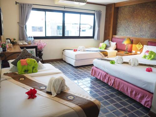 a room with four beds with stuffed animals on them at Your Place Inn in Karon Beach