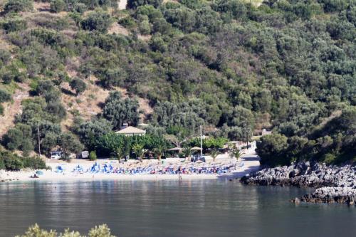 a group of people on a beach near the water at dell Mar stone house in Évyiros