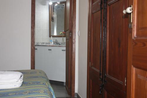 Casa Rural "ca Tona" في تشيلالا: غرفة نوم بسرير وحمام مع حوض
