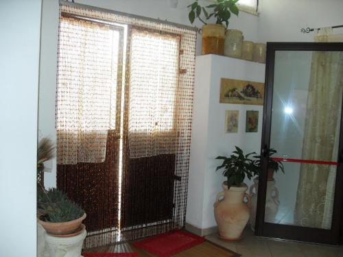 a room with a large window and a door with plants at Il Terrazzo Sul Sinni in Rotondella
