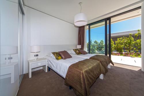 a bedroom with a large bed and a large window at Golden Rays Luxury Villas & Apartments in Primošten